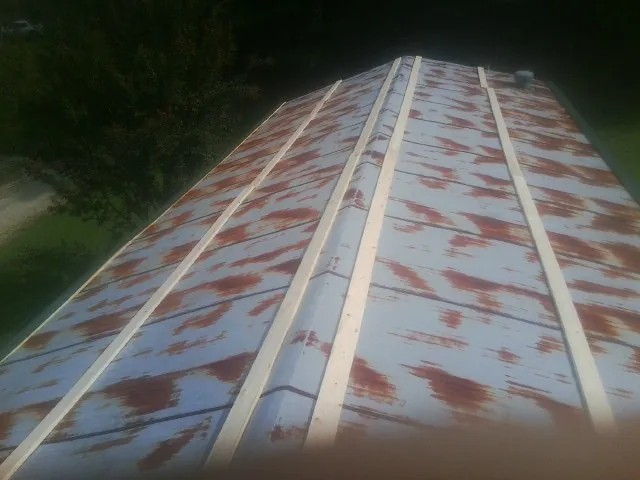 Rusted metal roof panels with new wood purlins before replacement — Storm Damage Roof Repair in Briggs by Roofing Brothers
